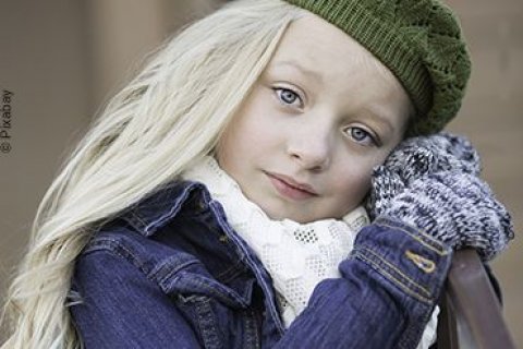 Kleines M&auml;dchen im Vorschulalter, herbstlich gekleidet, schaut mit einem nachdenklichen Blick in die Kamera