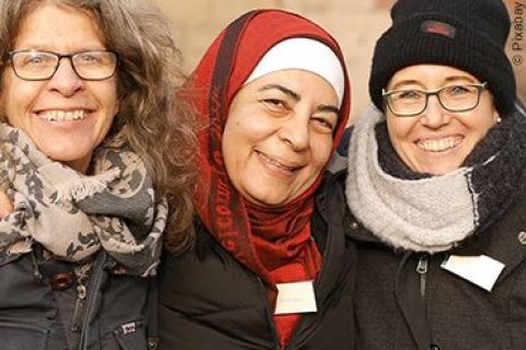 Drei Frauen, von scheinbar unterschiedlicher Nationalit&auml;ten, strahlen in die Kamera