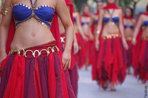 Versetzte Aufstellung einer Gruppe von weiblichen Personen im Stil orientalischer T&auml;nze mit einer T&auml;nzerin im Vordergrund