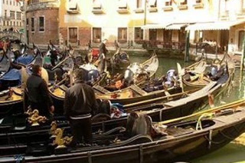 Am Ufer einer Gasse in Venedig sammeln sich Gondeln mit ihren Fahrern